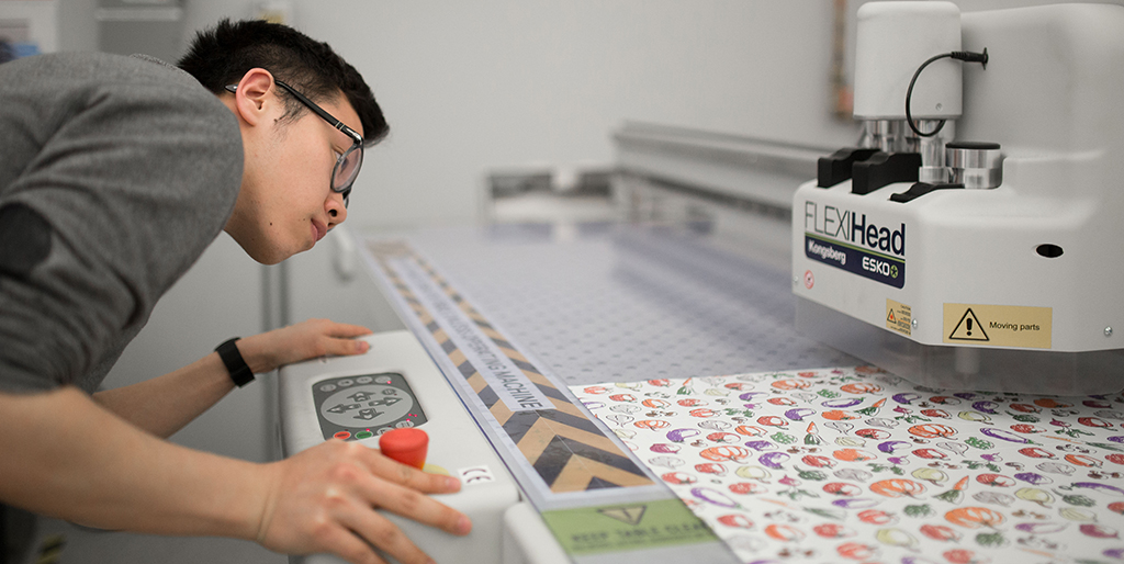 Student working with a packaging cutting table